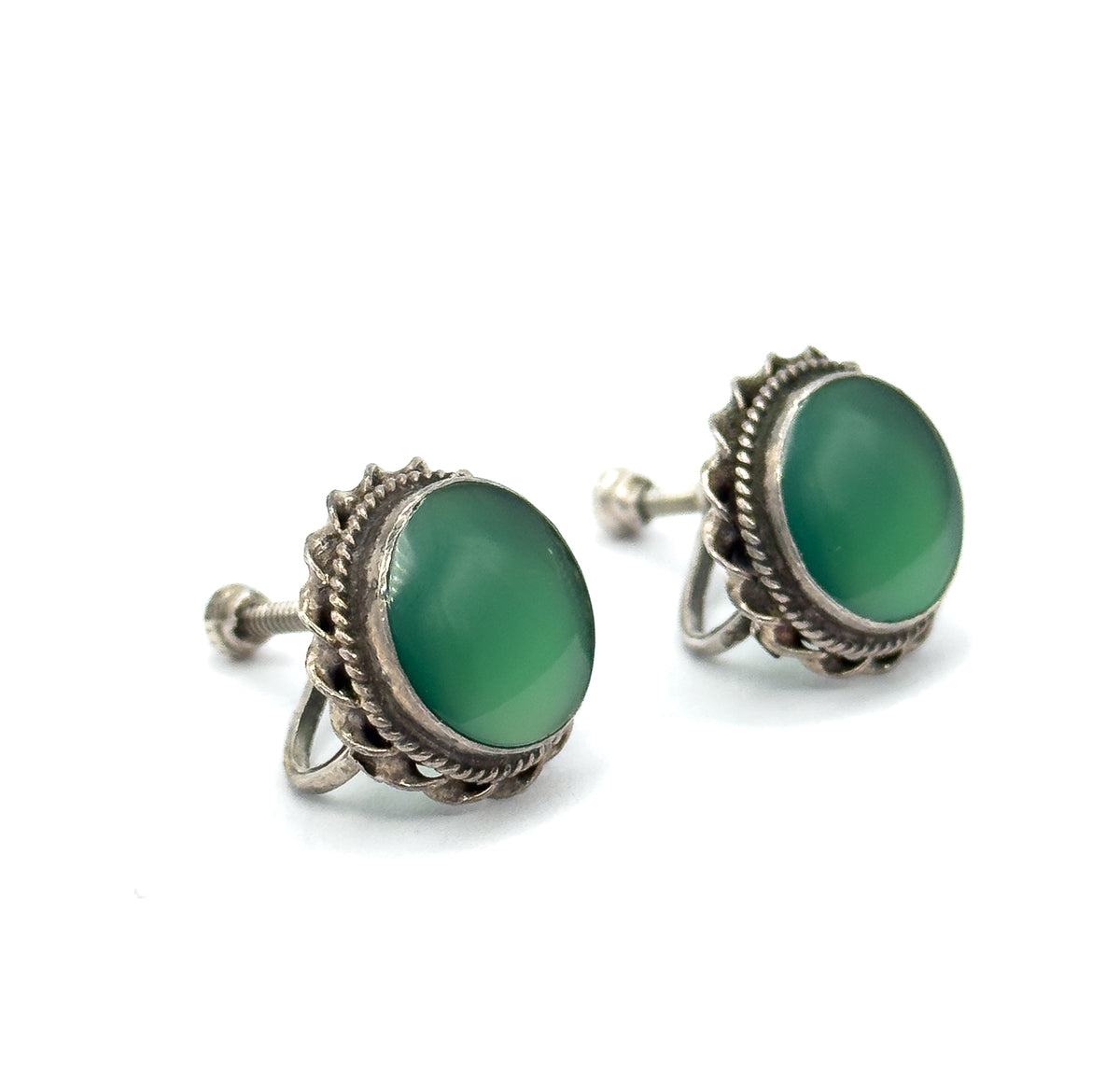 Chrysoprase cabochon earrings in sterling silver, shown as a pair angled on white, each green round stone bezel set within a cable-textured frame above a screw-back fitting.