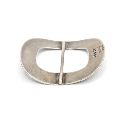 The plain reverse lies flat on white, showing the smooth underside, the central bar spanning the opening, and small maker's and "sterling" stamps at one edge.
