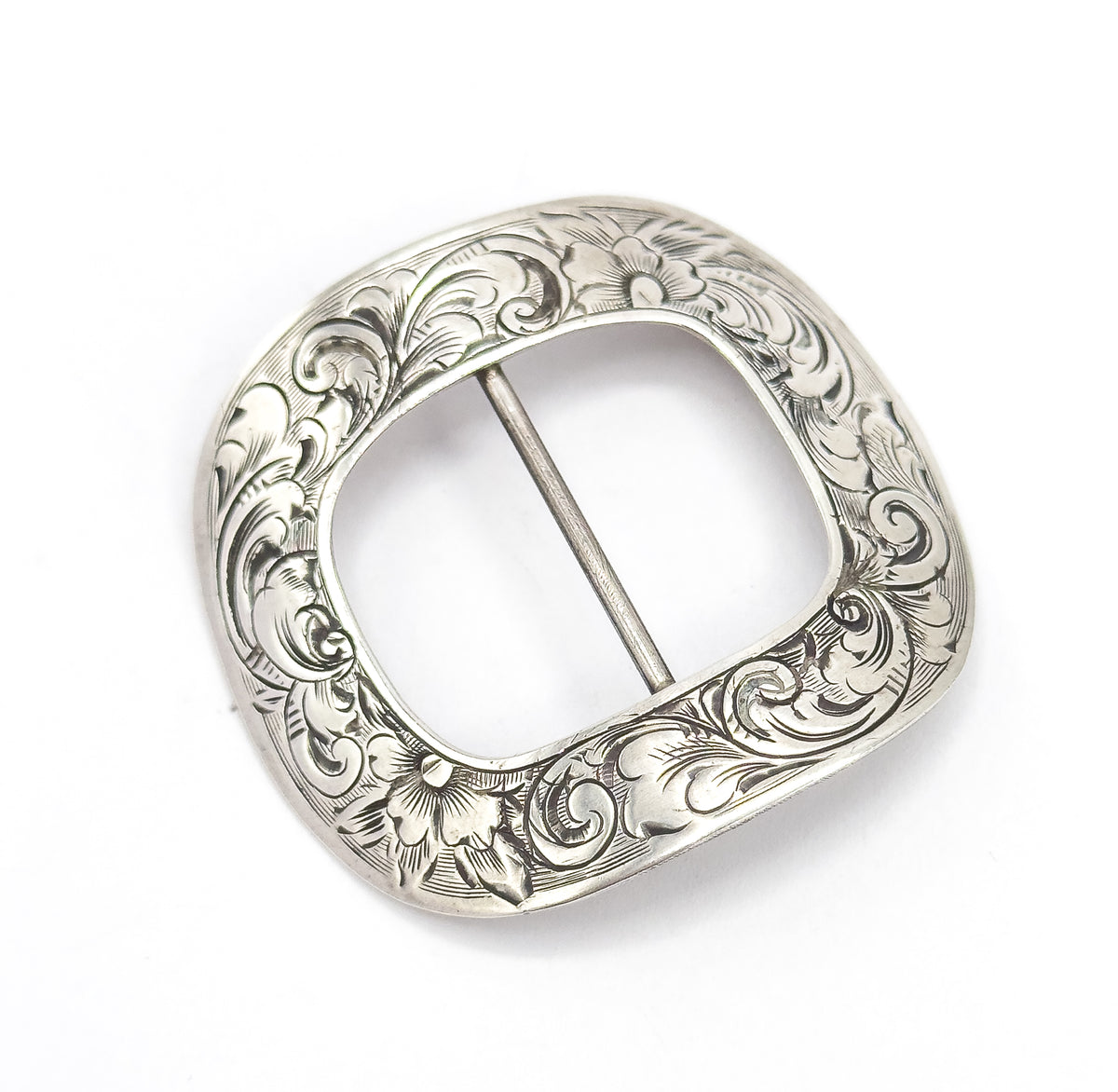 The engraved face seen straight on with the central bar running vertically, showing the squared-oval outline and a hand engraved flower at both the top and bottom of the scrolling border.