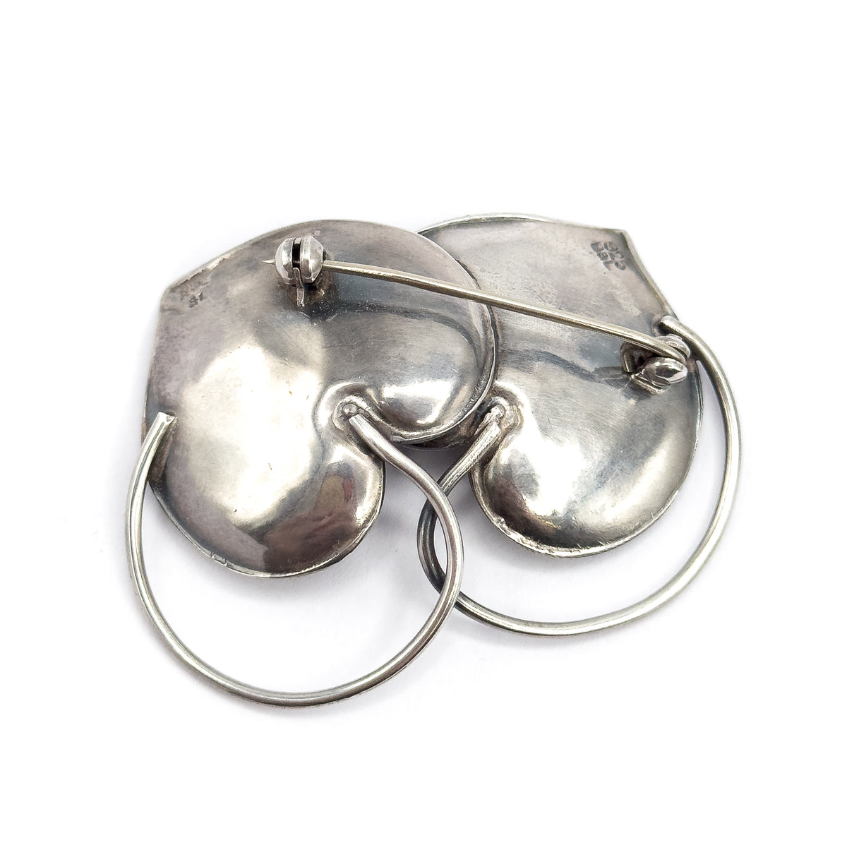 Sterling silver double heart infinity brooch shown from the back on a white background, with the pin stem, hinge and catch across the two domed hearts and the looping connector below.