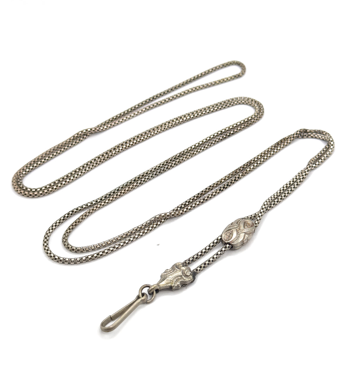 The whole chain laid out in long doubled loops on white, with both engraved sliding beads and the hook clasp gathered at the lower edge, showing its full sweeping length.