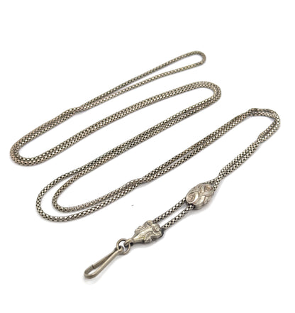 The whole chain laid out in long doubled loops on white, with both engraved sliding beads and the hook clasp gathered at the lower edge, showing its full sweeping length.