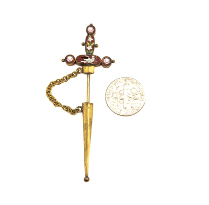 Shown beside a dime for scale, the pin stands upright with its mosaic hilt at top, the sheath threaded on the stem below and the chain looping to one side.