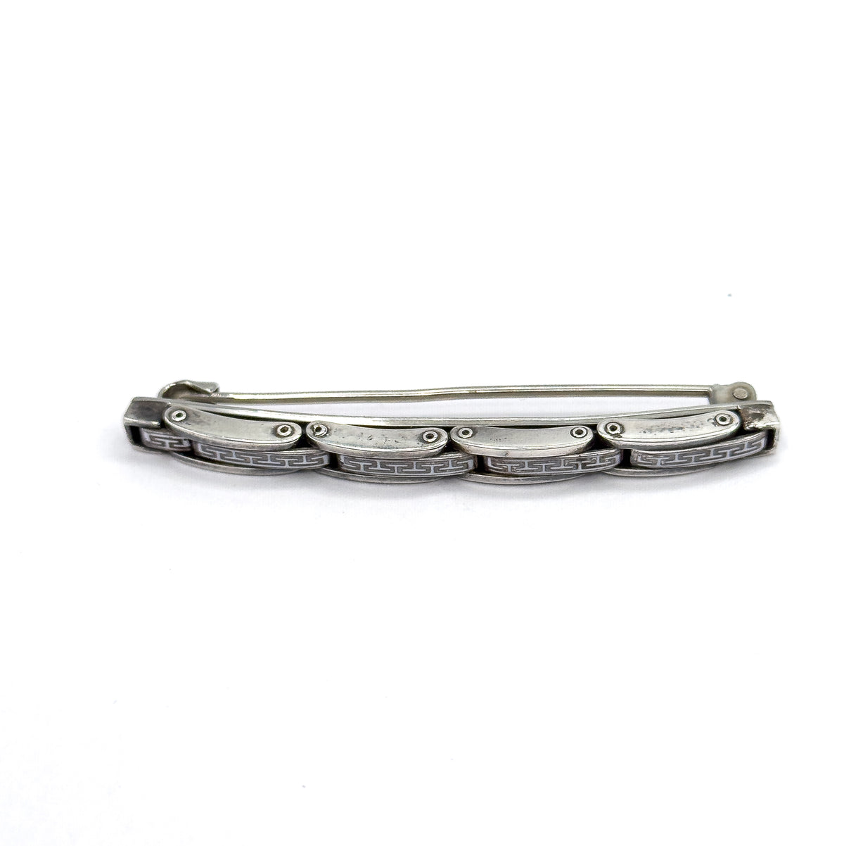 Viewed from behind and slightly below, the open pin stem arcs above the bar while the scalloped undersides of the linked plates and the hook catch at the right end come into view.