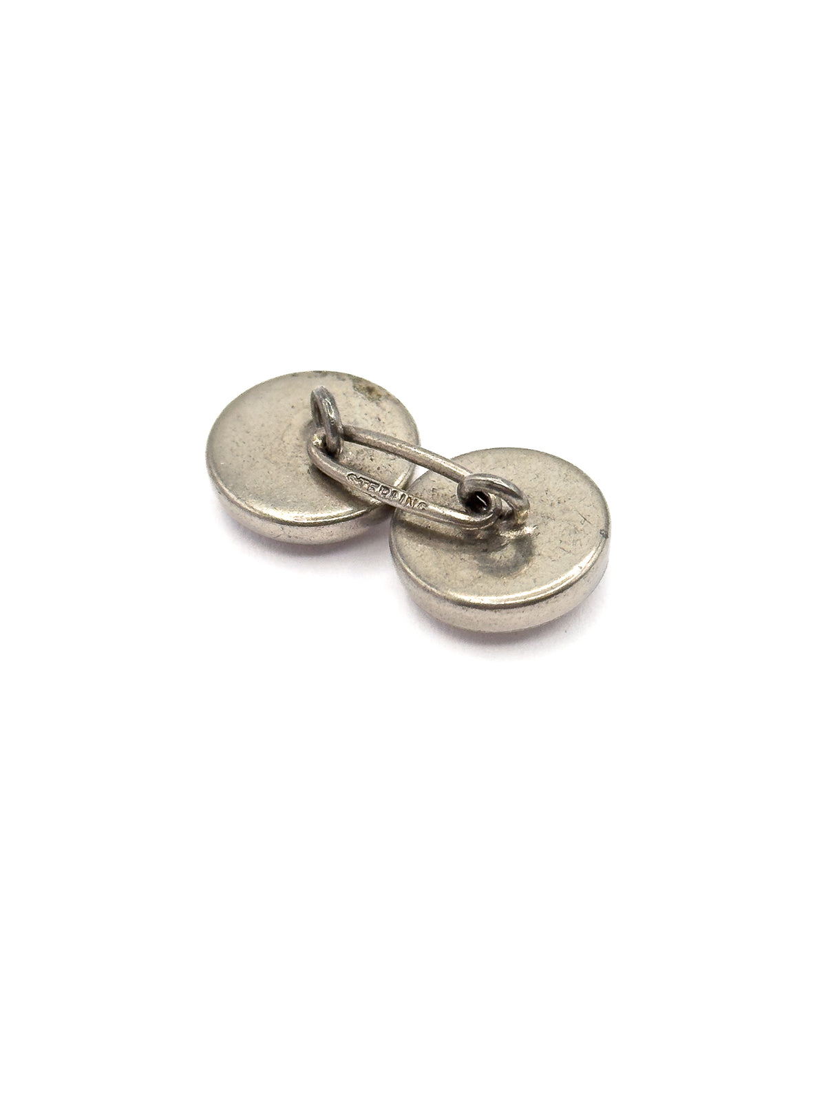 Reverse side shown against white, with the two plain round silver backs tilted apart and the curved connecting link and loops between them clearly visible.