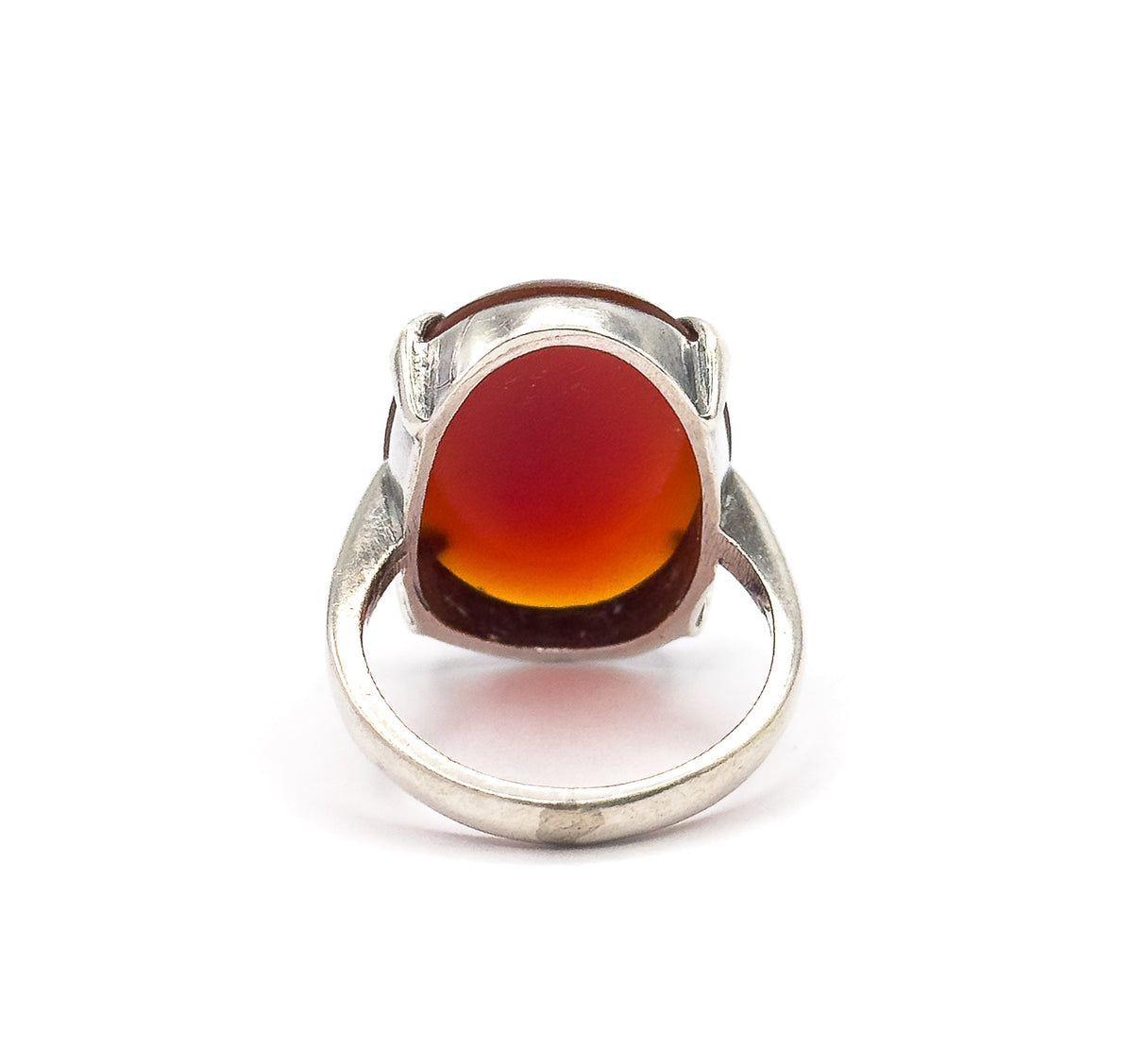 Front-on view against white with the oval red cabochon upright between its silver prongs and the full circle of the sterling silver shank visible behind and below it.