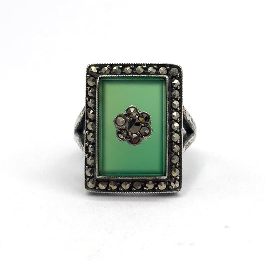Straight down onto the flat rectangular face, the chrysoprase and its marcasite flower centred within the full square halo, the shank tucked out of sight behind the bezel.