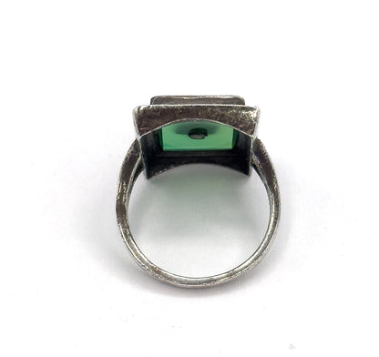 Viewed from beneath and behind, the open back of the bezel reveals the underside of the green chrysoprase with its small central drill hole, framed by the darkened silver shank.