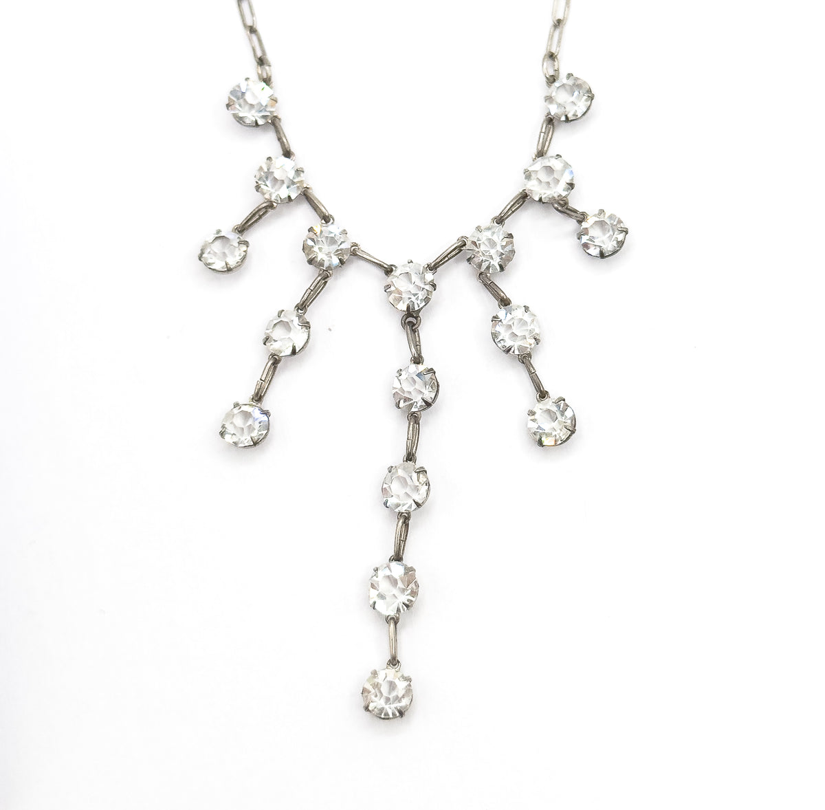 Symmetrical head-on view of the whole fringe spread flat, each prong-set paste stone branching outward in pairs while the central strand drops longest, ending in a single stone.