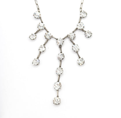 Symmetrical head-on view of the whole fringe spread flat, each prong-set paste stone branching outward in pairs while the central strand drops longest, ending in a single stone.