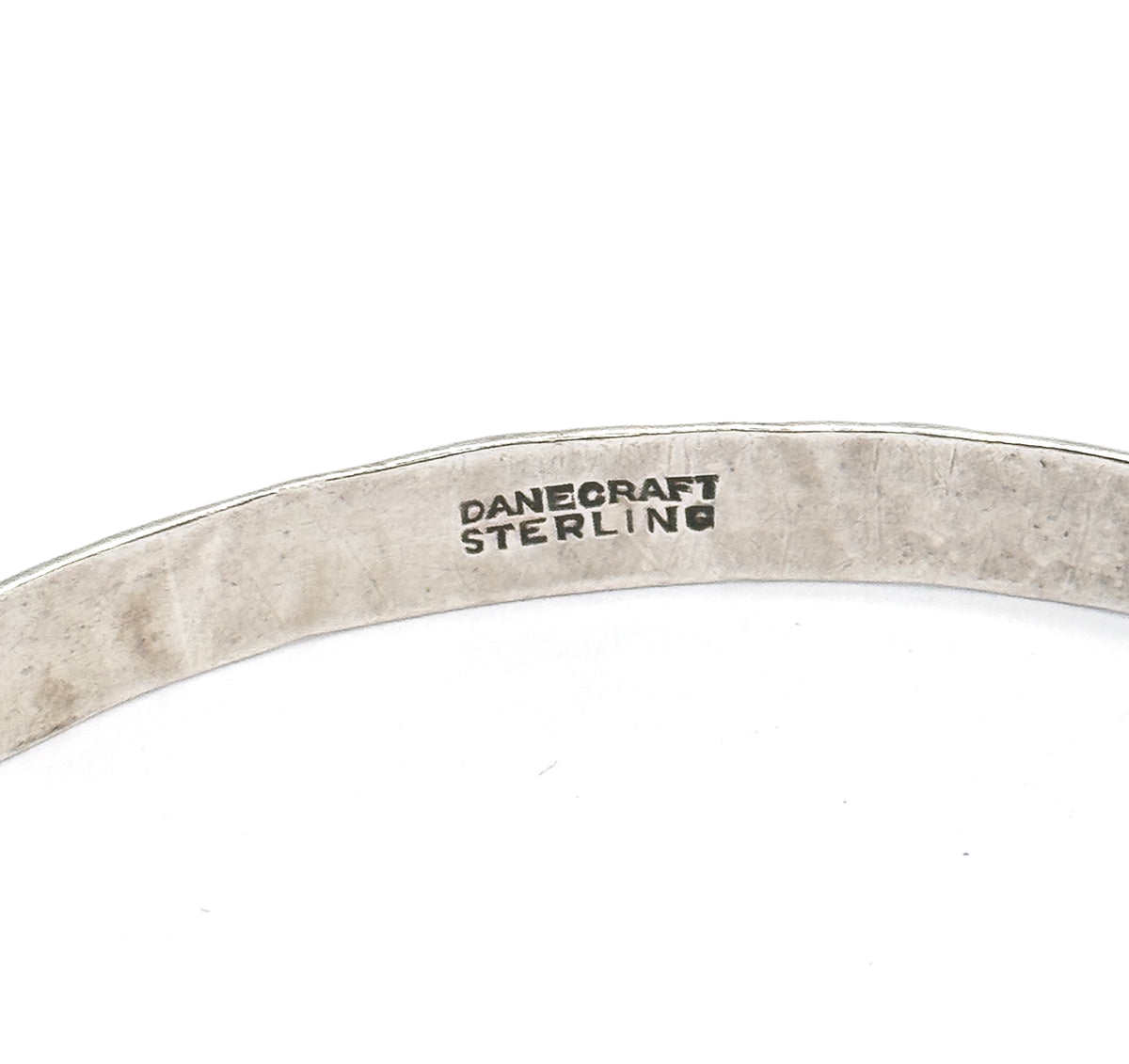 Close-up of the smooth inner surface of the band, where the maker's stamp reading "Danecraft Sterling" is struck in small block letters.