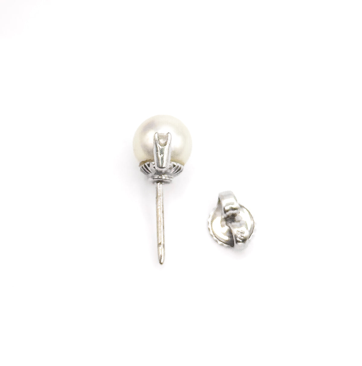 A mid-century pearl and diamond earring in 14K white gold, shown on its side against white with the long post and buttercup gallery visible, its separate post back lying alongside.