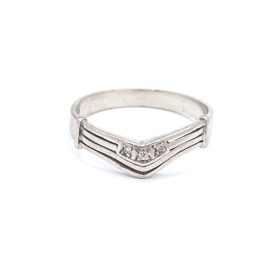 Front view from slightly above, so the chevron's three small diamonds sit level with the eye while the far side of the shank curves visibly behind the grooved point.