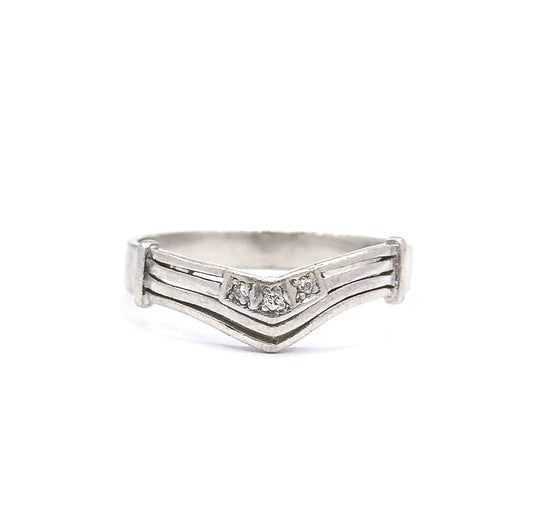 Almost the same view with slightly different angle, the band level and evenly lit so the grooved chevron arms, three small diamonds and low profile read clearly against plain white.