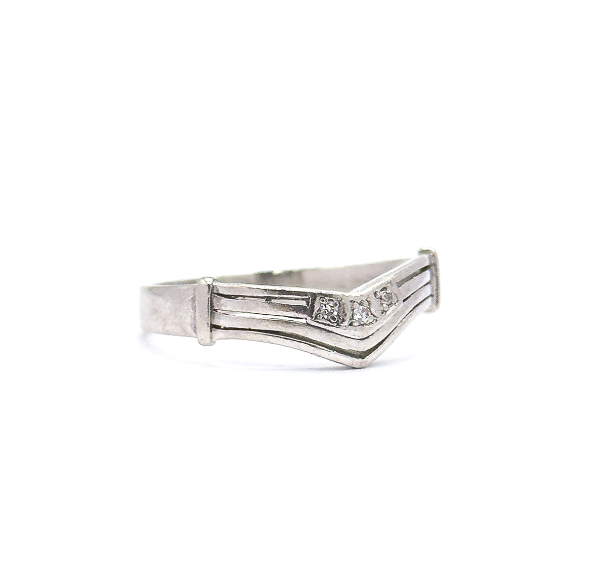 The band alone against white, seen side-on so the grooved chevron shank, flat end caps and the three tiny diamonds at the point of the V are all visible.
