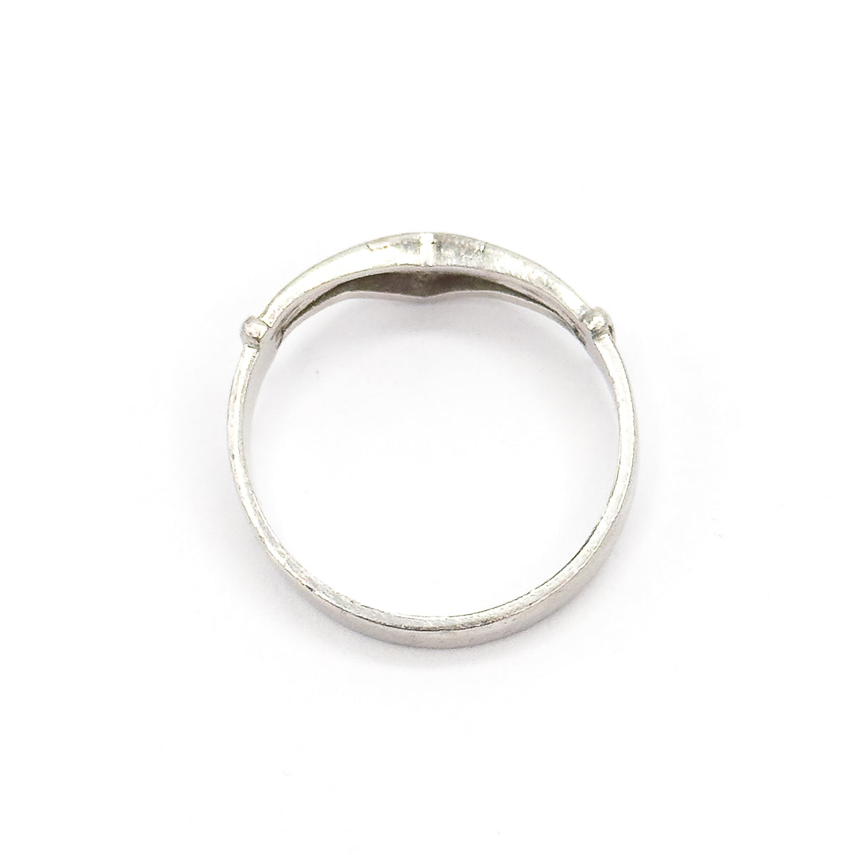 Viewed through the open circle of the band, showing the smooth inner surface of the shank and the underside of the V where the diamond settings sit.