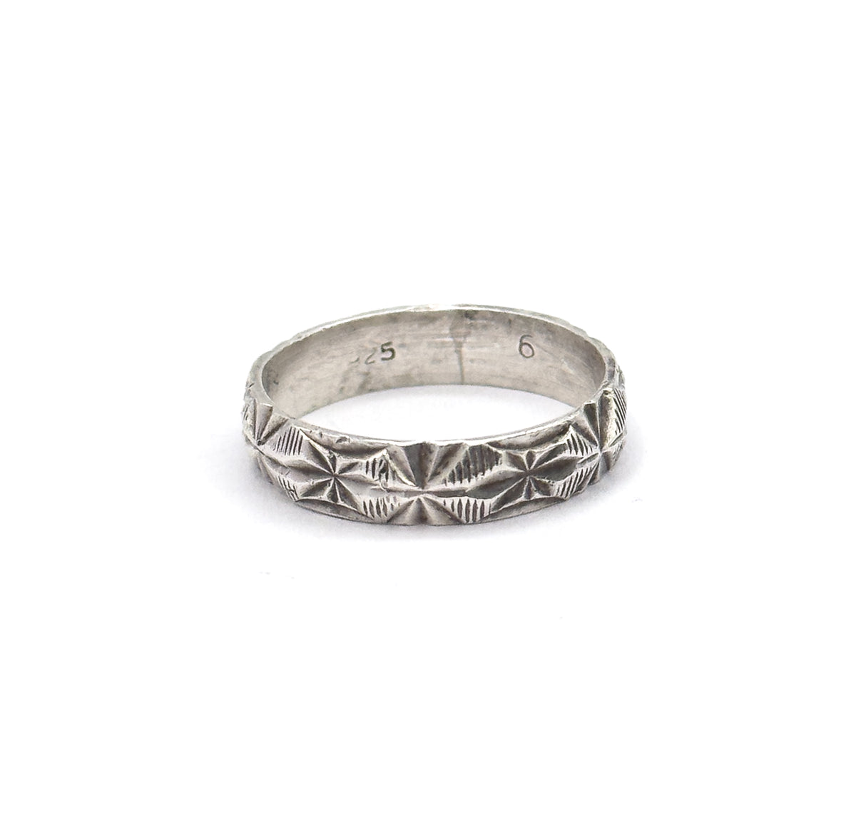 Almost the same view with slightly different angle, the upright band tilted so the light grazes the rows of starburst facets and the fine coin-edge borders along both rims.