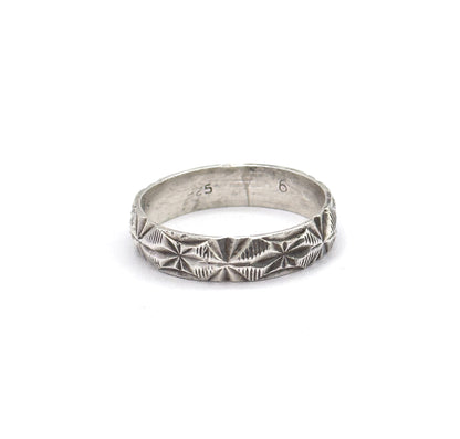Almost the same view with slightly different angle, the upright band tilted so the light grazes the rows of starburst facets and the fine coin-edge borders along both rims.