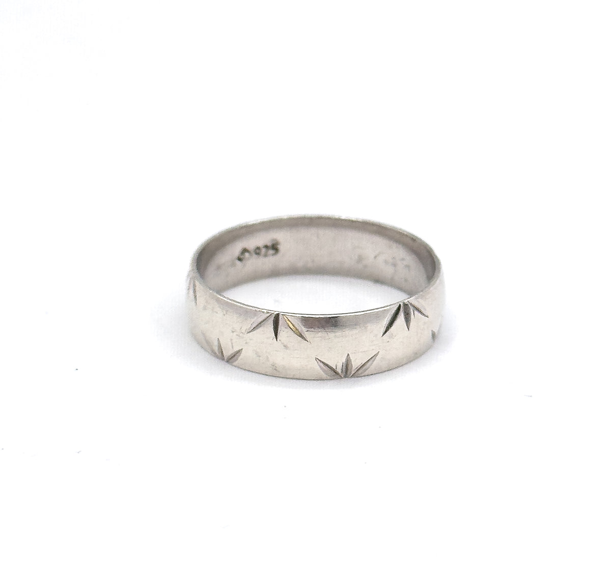 Standing upright on white with the interior turned toward the viewer, so the stamped marks inside the shank are legible above the row of star-cut facets.
