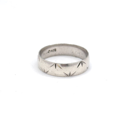 Standing upright on white with the interior turned toward the viewer, so the stamped marks inside the shank are legible above the row of star-cut facets.