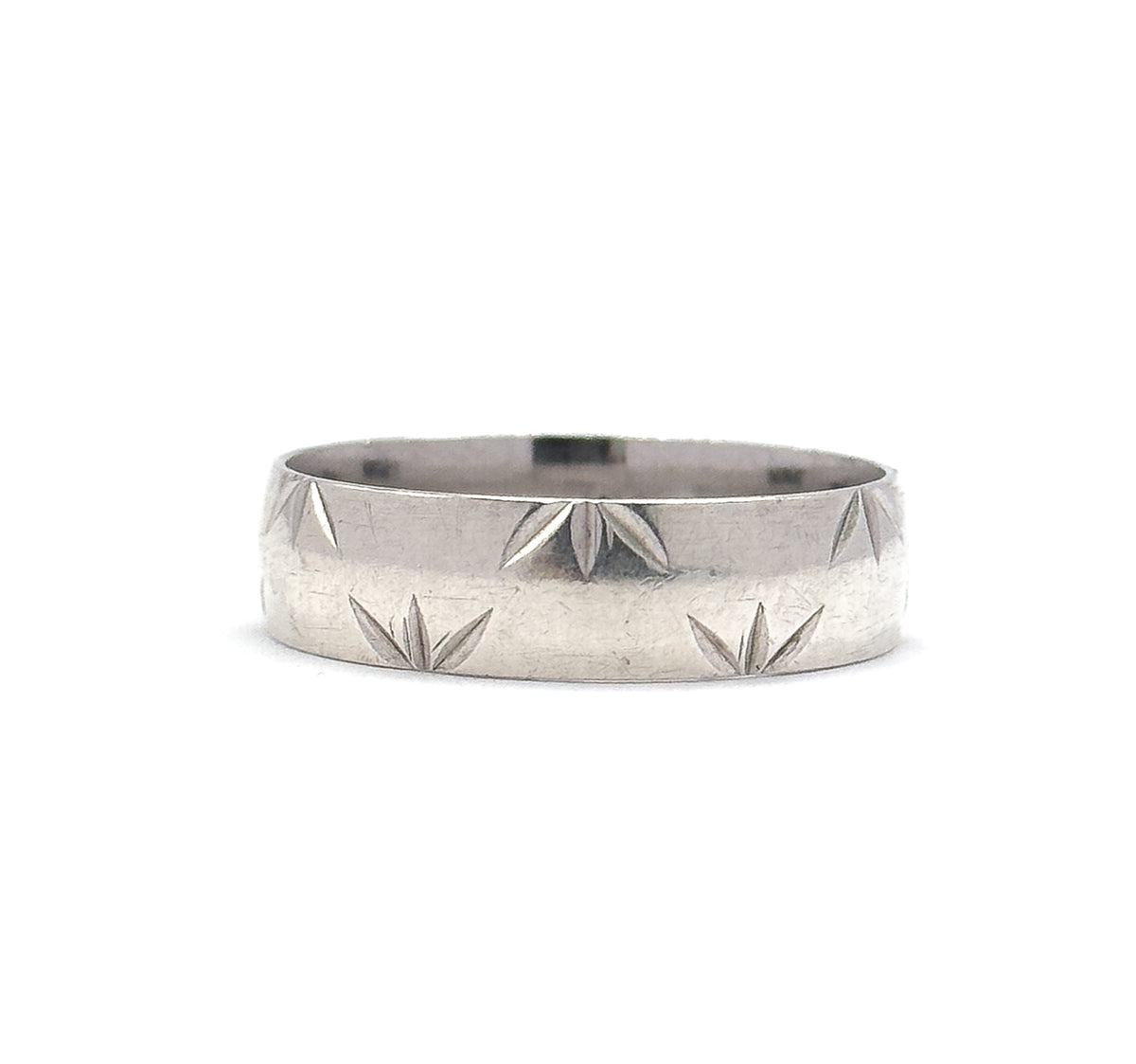 A level, straight-on view at eye height, the sterling silver band's full width filling the frame so the star cuts sit along both rims with a smooth stripe between them.