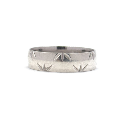 A level, straight-on view at eye height, the sterling silver band's full width filling the frame so the star cuts sit along both rims with a smooth stripe between them.