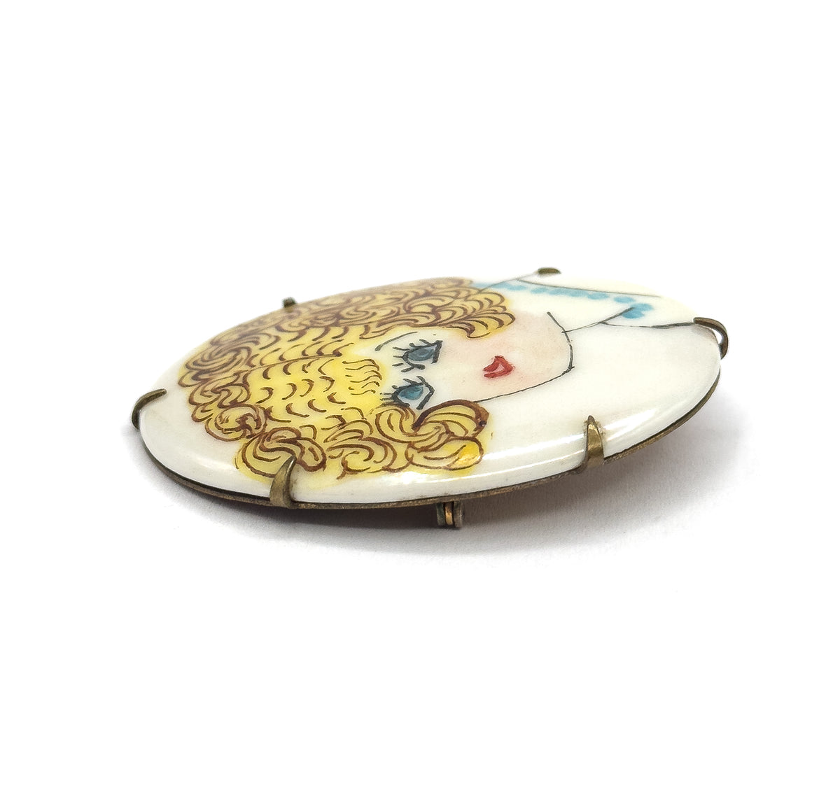 Seen nearly edge-on from the front, the oval tilts away so the flapper's face is foreshortened, revealing the frame's depth, the prong tips along the rim and the closed pin hardware beneath.