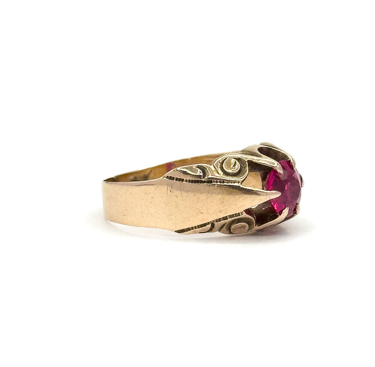 Almost the same view with slightly different angle, turned so the stone sits at the right edge and the engraved swirl on the near shoulder faces the camera along the wide polished shank.