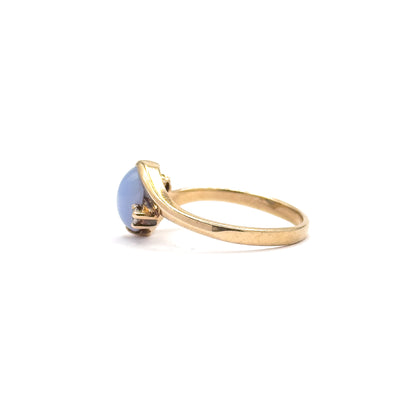 Straight side elevation at eye level, showing how flat the domed cabochon sits in profile and how the band's narrow shank widens smoothly forward into the setting's shoulders.