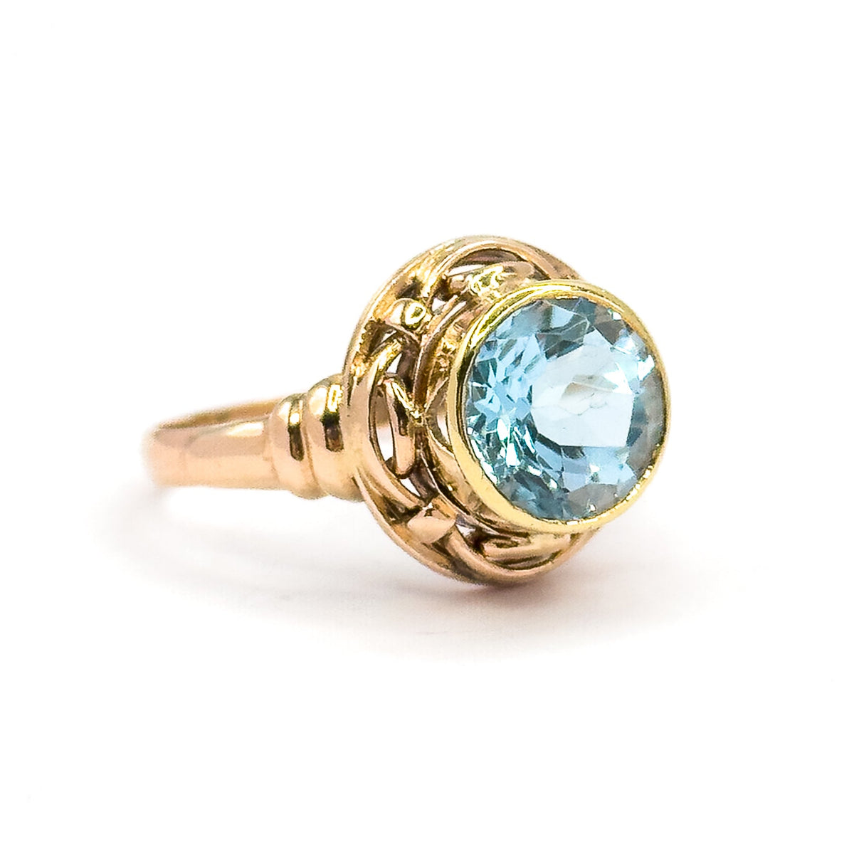 Off the hand now against a plain white background, seen from the side so the yellow gold bezel, the interlaced rose gold knotwork gallery and the slim tapering shank stand clear.