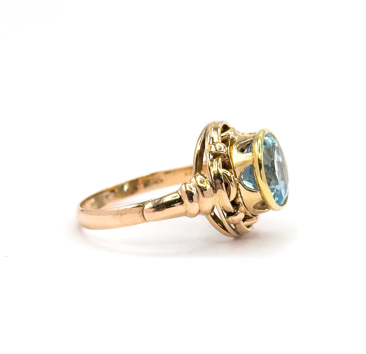 Almost the same view with slightly different angle, the stone turned further toward the camera so light passes through the open sides beneath the yellow gold bezel and the knot loops.