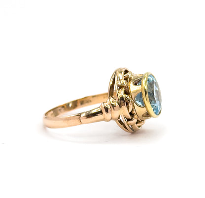 Almost the same view with slightly different angle, the stone turned further toward the camera so light passes through the open sides beneath the yellow gold bezel and the knot loops.