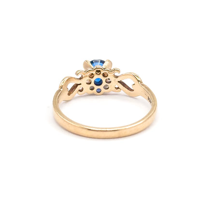 Another rear view, tilted lower so the cobalt spinel peeps over the top of the open gallery and the pierced scrolled shoulders flank it on either side of the yellow gold shank.
