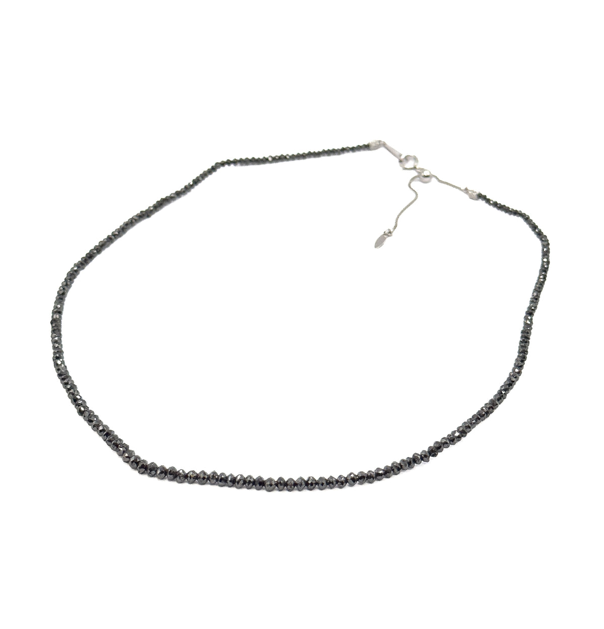 The whole necklace laid open in a full oval on white, showing the complete strand, the fine white gold chain at the back and its sliding adjustable section with drop-shaped end tag.
