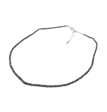 The whole necklace laid open in a full oval on white, showing the complete strand, the fine white gold chain at the back and its sliding adjustable section with drop-shaped end tag.
