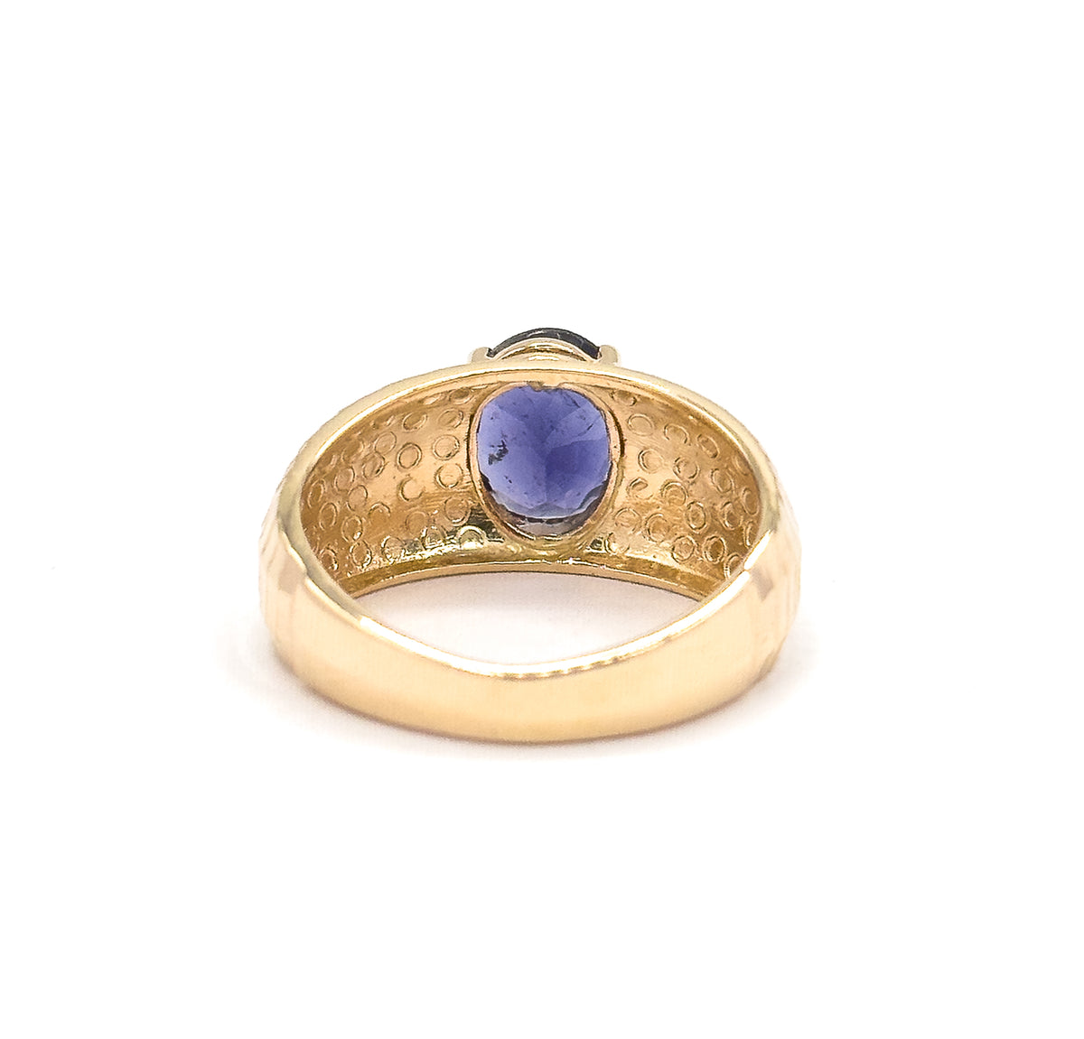 Almost the same view with slightly different angle, looking through the finger opening from behind, the oval iolite glowing violet-blue under the dimpled inner band and tapering shank.