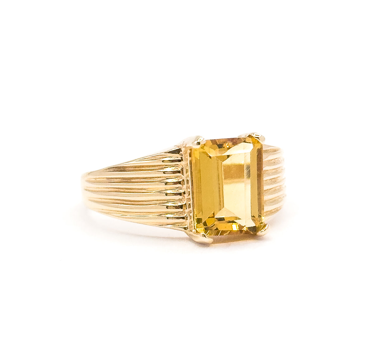 A three-quarter side view off the hand, the citrine's deep faceted side visible between its corner prongs while the ribbed shoulders run their full length down to the narrow shank.
