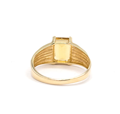Viewed from behind, the open back of the setting frames the citrine's underside between the corner prongs, with the ribbed shoulders sweeping down to the plain tapered shank.