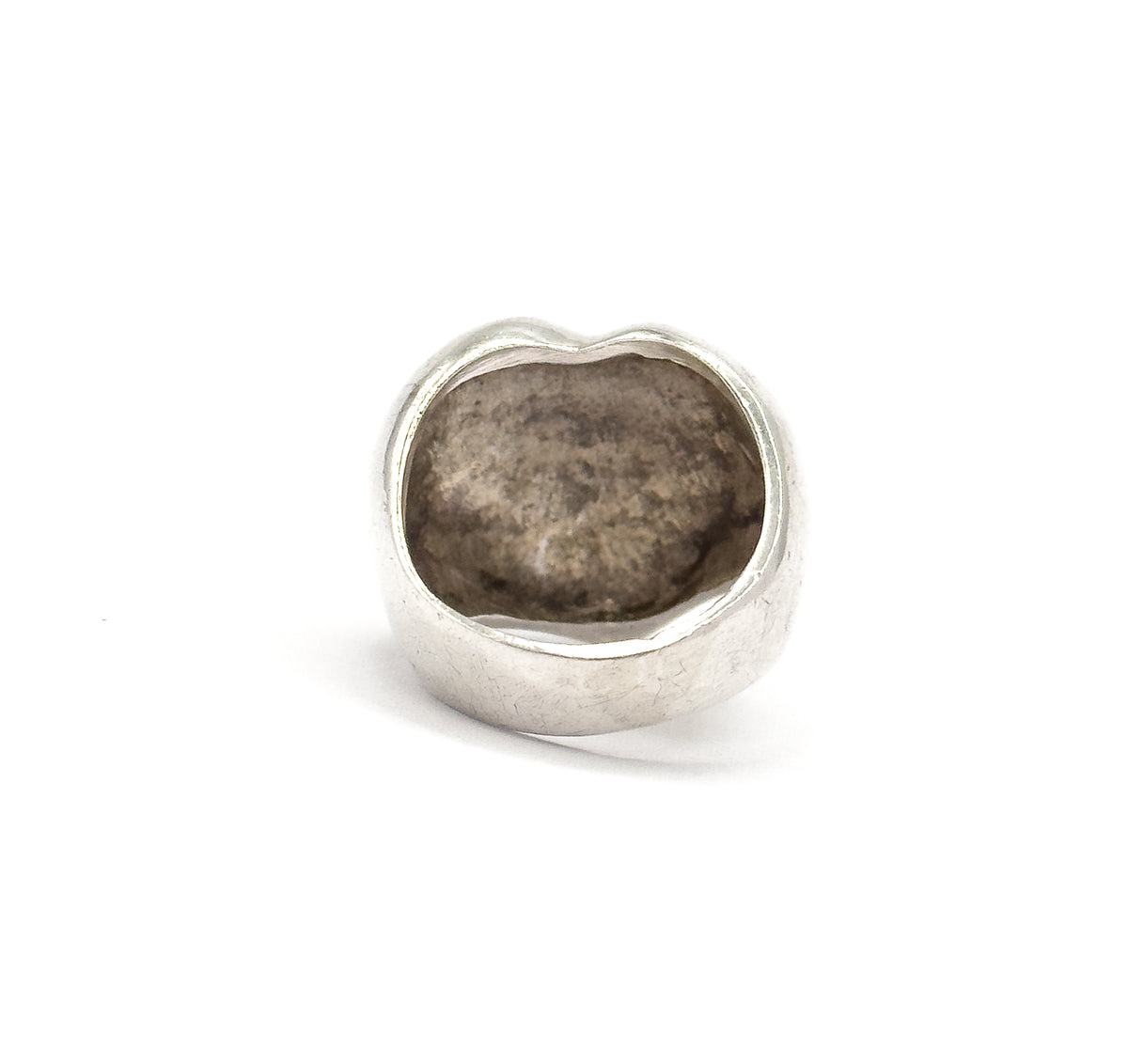 Looking straight into the hollow back of the heart, the recessed interior shows soft darkened patina while the light-coloured band sweeps broad across the base of the shank.