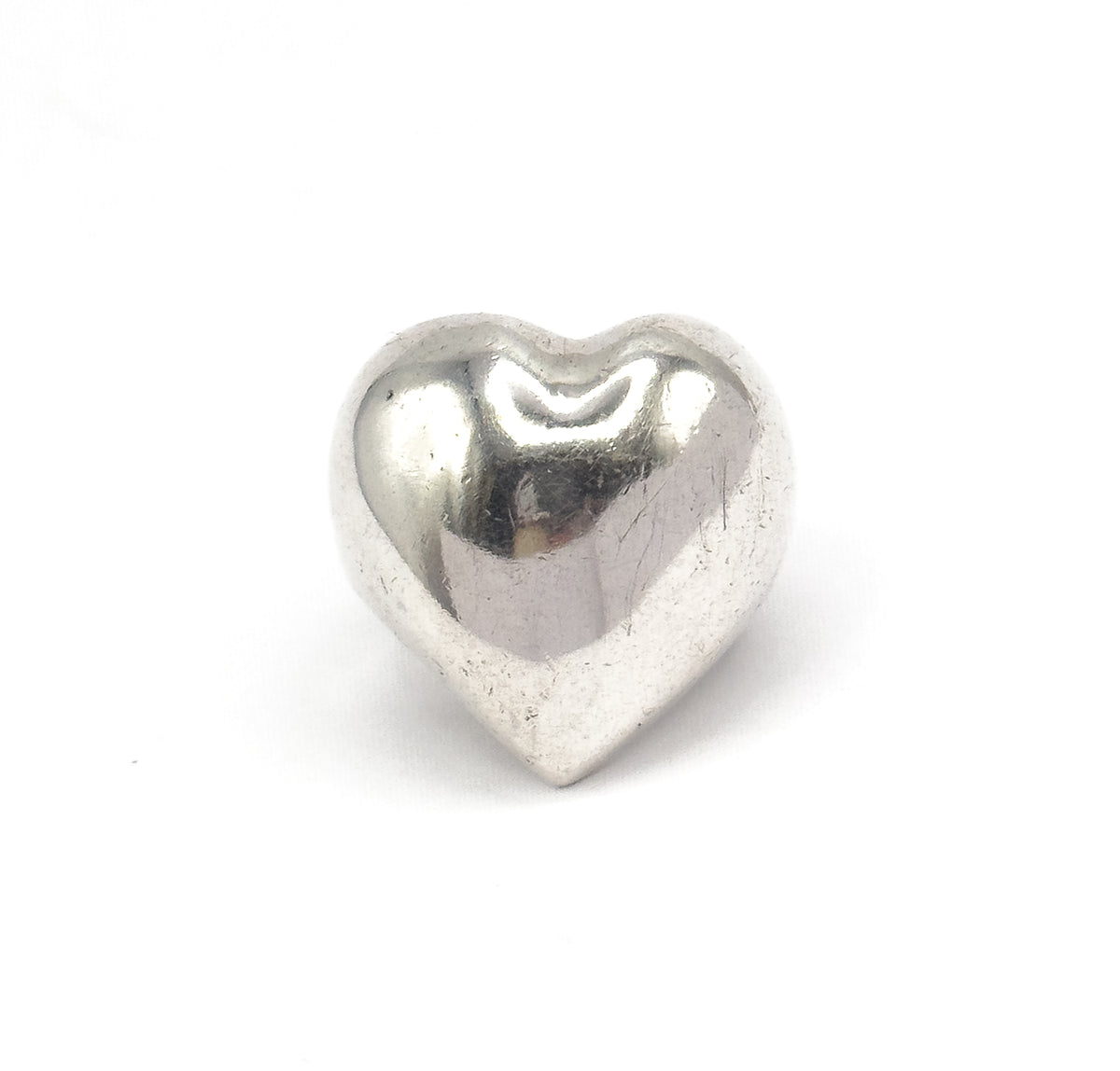 Almost the same view with slightly different angle, the whole polished heart sits centred against white, its dipped cleft at the top and tapering point at the base fully in frame.