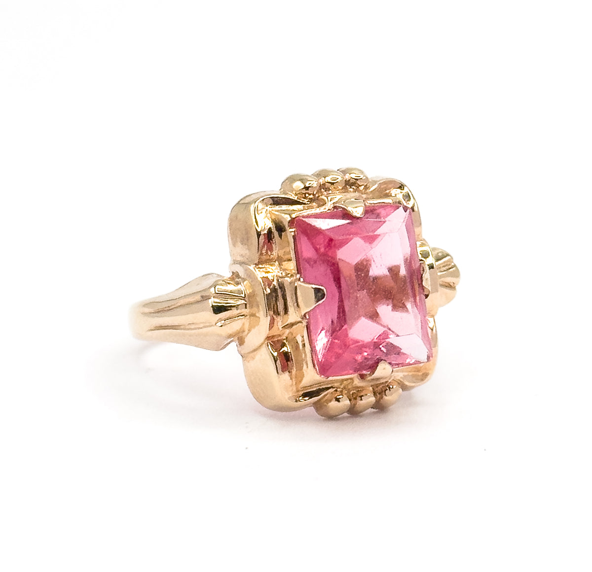 Standing upright on a plain white background, the ring is seen off the hand in three-quarter view, showing the beaded accents above and below the bezel and the tapering shank in profile.