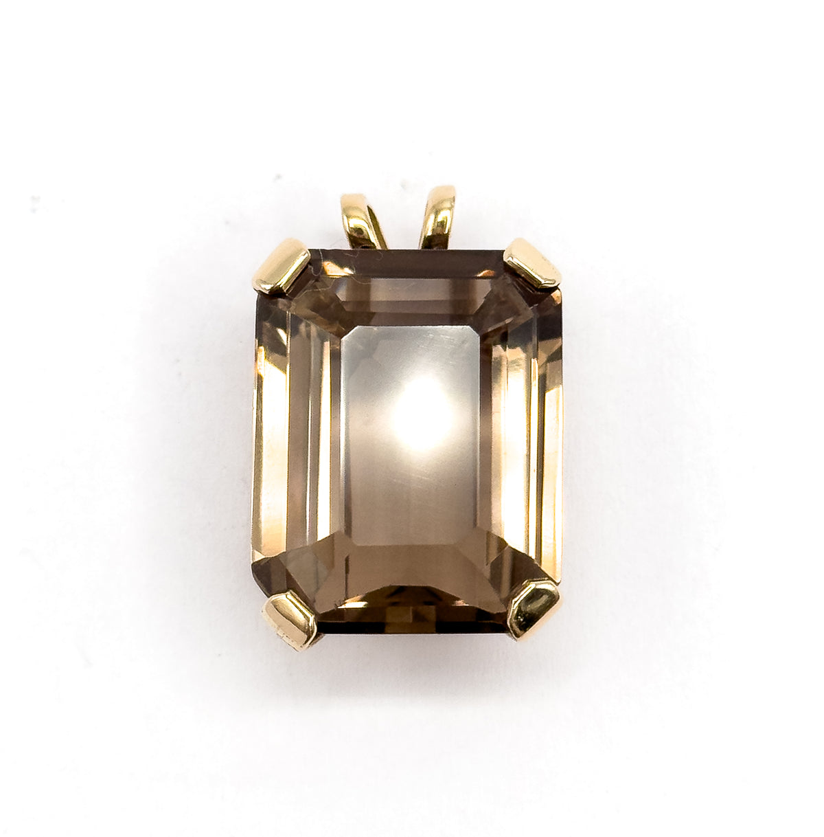 Square-on from the front, the golden brown emerald-cut quartz is centred with a bright highlight at its table, the split yellow gold bail standing clear above the four prongs.