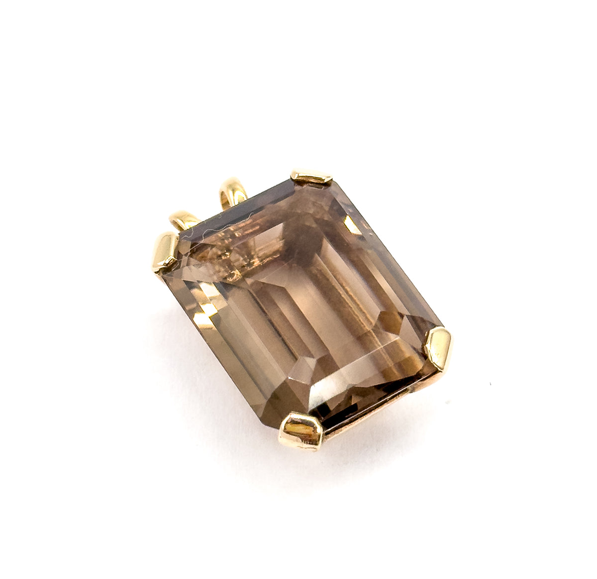 Looked straight down onto the table, the emerald-cut stone set diagonally in the frame so its step facets and corner bevels read clearly, the bail tucked out of sight behind the upper left prongs.