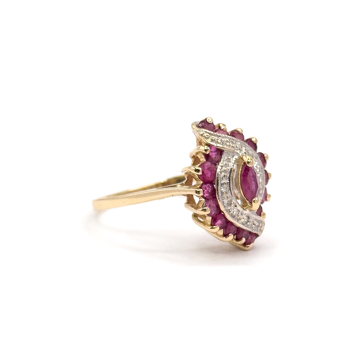Side-on profile against white, the head tilted toward the viewer so the white gold waves curving around the marquise ruby and the low-set yellow gold shank are seen edge to edge.