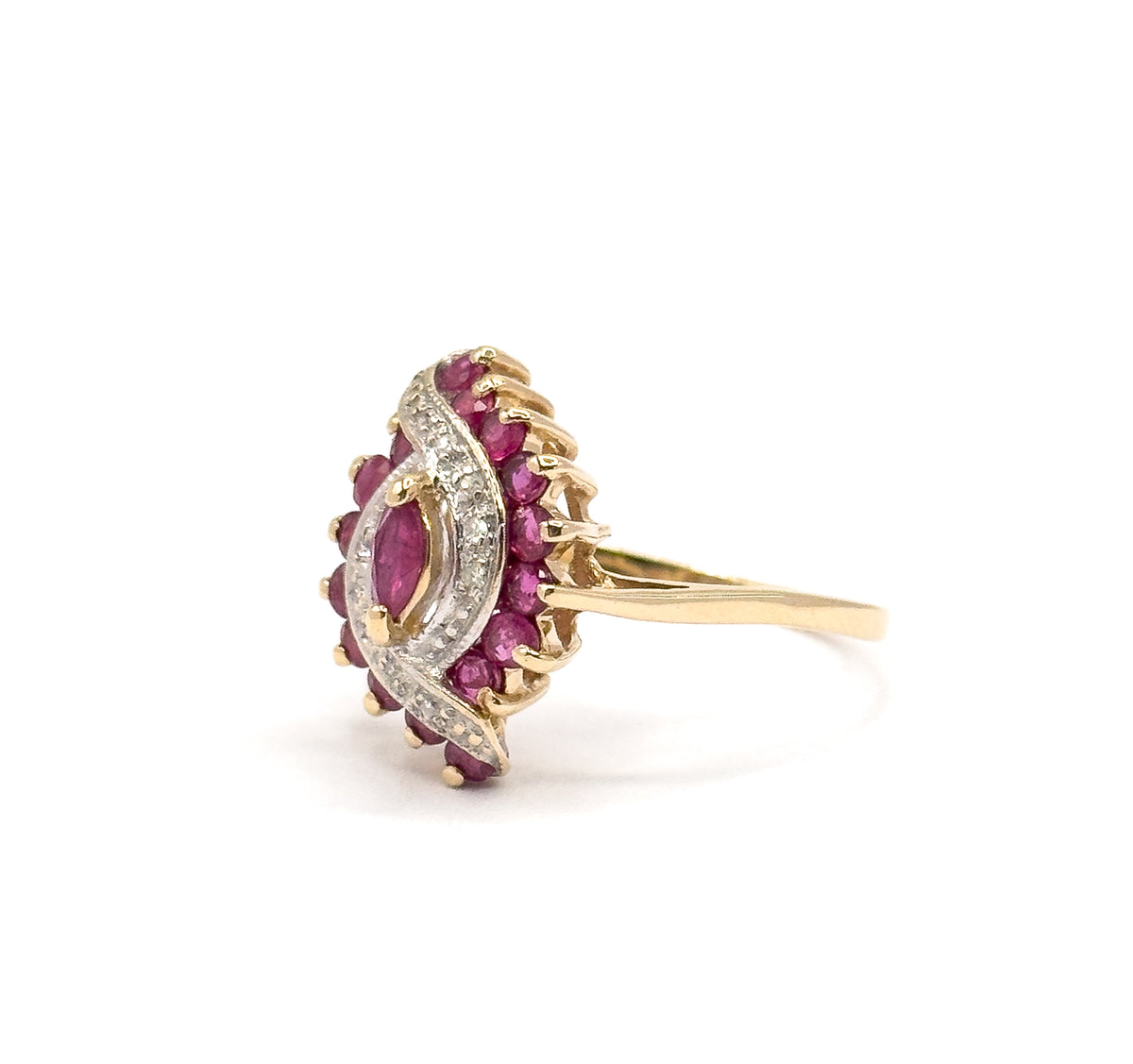 Profile from the right with the head angled slightly forward, so the diamond-set white gold wave sweeping past the marquise ruby reads clearly against the thin yellow gold shank behind it.