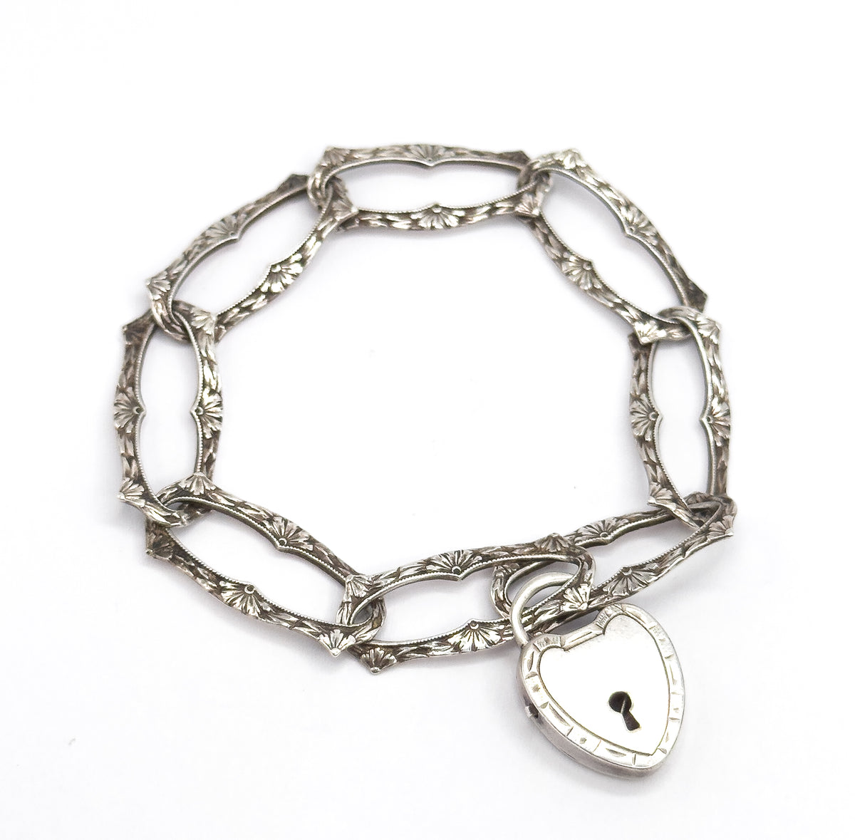 Almost the same view with slightly different angle, the ring of links tipped slightly forward so the heart lock clasp sits nearer the viewer, its keyhole and banded edge clearly shown.