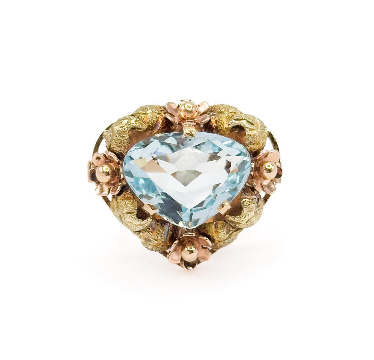 Straight-on view of the face alone, the icy blue aquamarine prong-set at the centre with rose gold flowers at top, bottom and both sides between green gold leaves, the shank hidden behind.