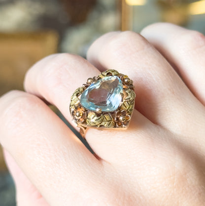 Close view from the side of the hand, showing how high the ring's floral face stands above the finger, with the prongs and rose gold flower heads catching the light.