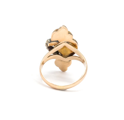 Art Nouveau opal and ruby enamel ring in yellow gold, shown upright from behind so the open back of the setting and the slender tapering shank are visible against a white background.