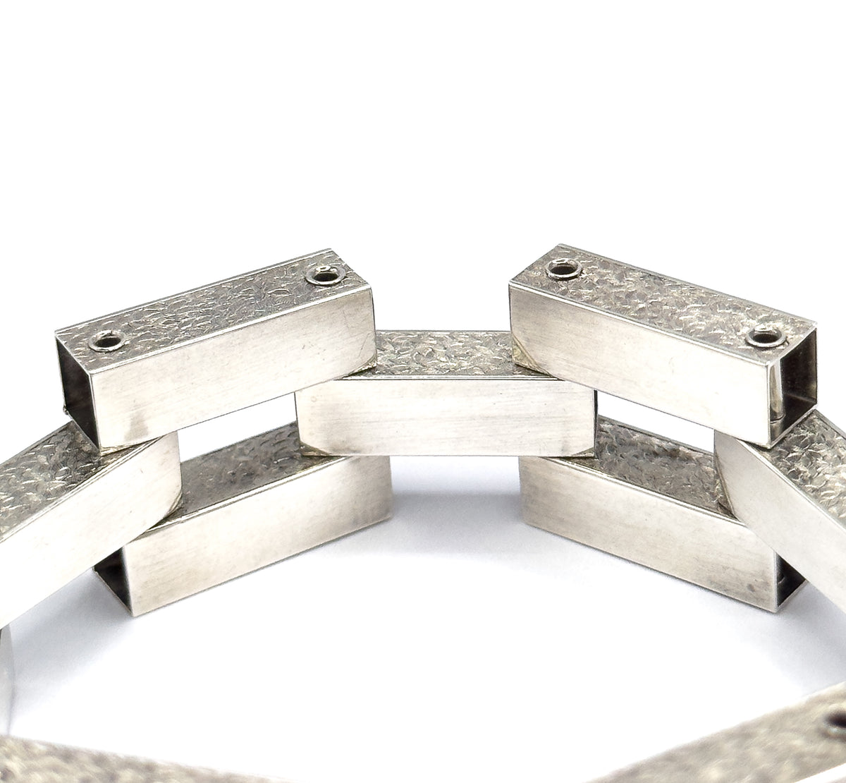 Looking down into the standing circle from above, the flat polished tops of the bars show their hinge pin heads while the open bar ends reveal the hollow interiors of each gate link.